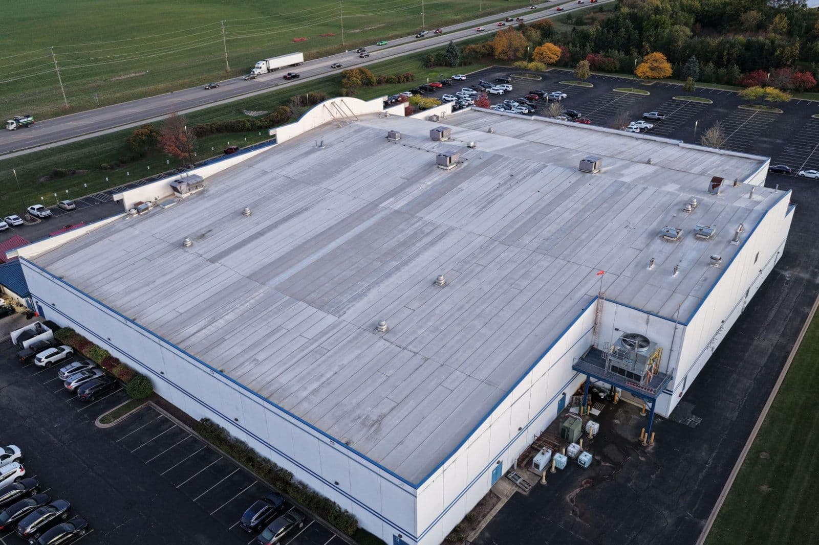 Aerial view of a commercial flat roof beside a highway